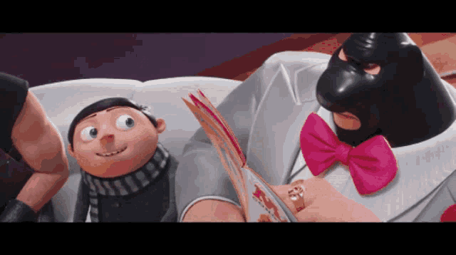 a man in a pink bow tie is reading a book to another man