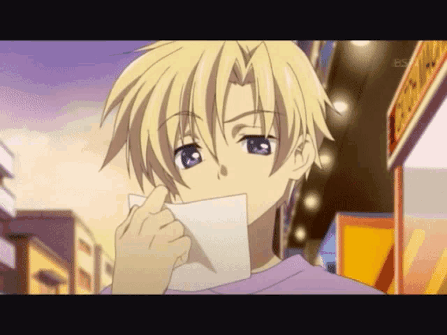 a boy with blonde hair is holding a piece of paper