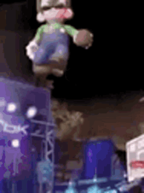 a stuffed animal is flying through the air while standing on a stage .
