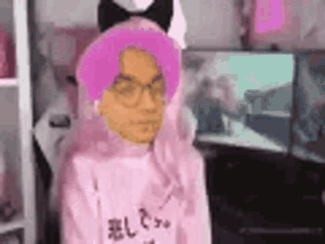 a man with pink hair and glasses is wearing a pink sweater and a cat ear headband .