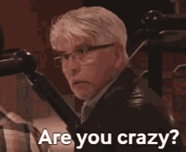 a man with glasses says " are you crazy " in front of a microphone