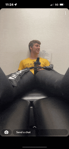 a man wearing a yellow shirt that says fearless sits on a chair