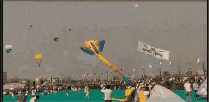 a group of people are flying kites in a field with a banner that says ' freedom ' on it