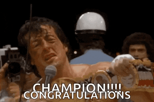 a man is crying while holding a boxing ring in front of a microphone and saying `` congratulations '' .