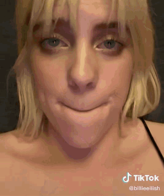 a close up of billie eilish making a funny face with her mouth open