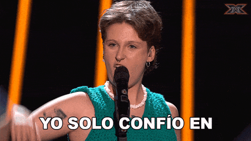 a woman singing into a microphone with yo solo confio en written on the bottom