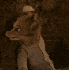 a stuffed animal with a blue shirt on is sitting in a cave