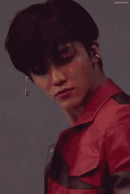 a close up of a person wearing a red jacket and black vest .
