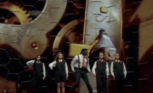 a group of people are standing in front of a clock that says ' s ' on it