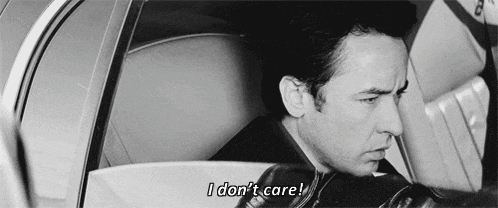a man is sitting in a car with the words `` i don 't care '' written on the screen .