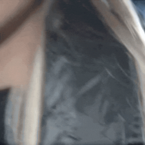 a close up of a woman 's face with a feathered jacket on