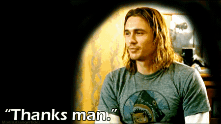 a man with long hair is wearing a shark shirt and says thanks man