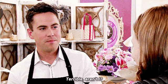 a man in an apron is talking to a woman and says " terrible aren 't i "