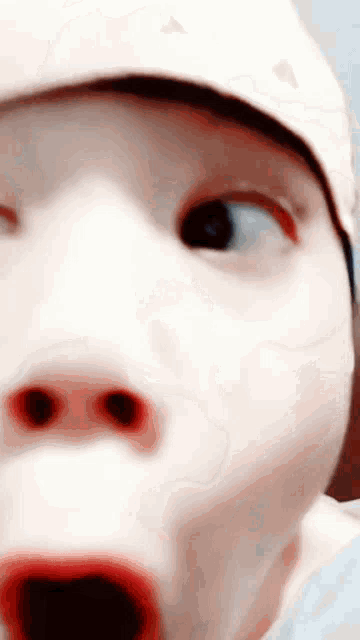 a close up of a baby 's face with a surprised look on his face