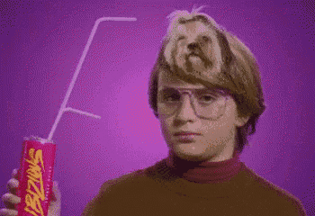 a boy is holding a can of swizzer with a straw sticking out of it .
