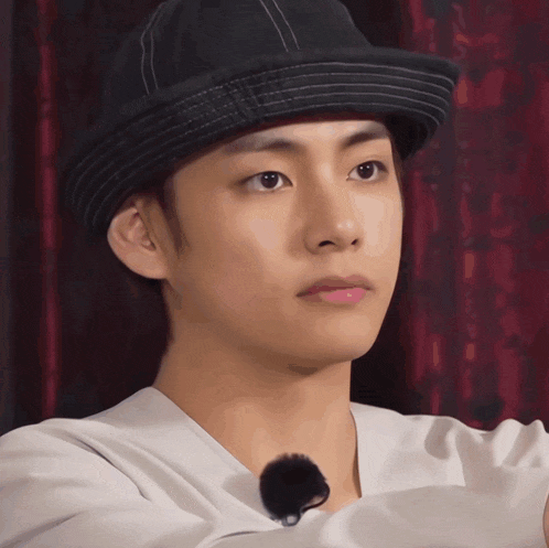 a young man wearing a hat and a white shirt