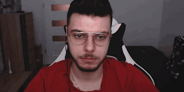 a man wearing glasses and a red shirt