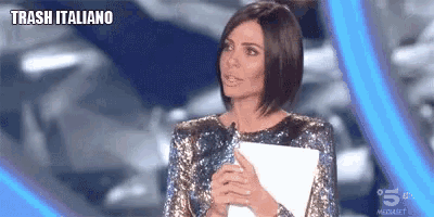 a woman in a sequined top is holding a piece of paper with trash italiano written on the bottom