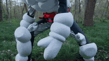 a person in a robot costume is standing in the woods