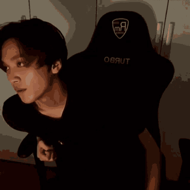 a young man is sitting in a gaming chair .