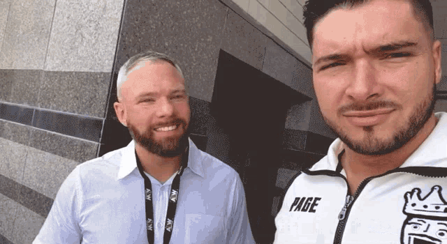two men are posing for a picture and one has the word page on his shirt