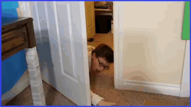 a man with glasses is peeking out of a doorway