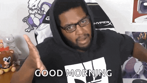 a man wearing glasses and a black hoodie is saying good morning