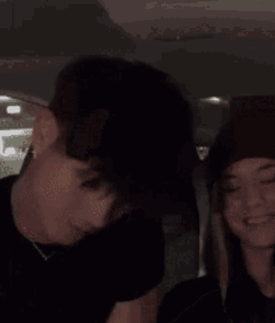 a man and a woman are sitting in a car