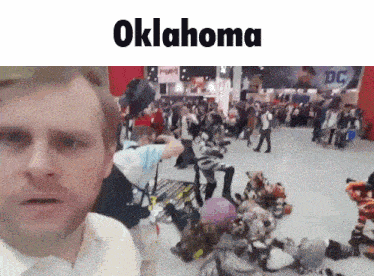 a man is standing in front of a crowd with oklahoma written on the top