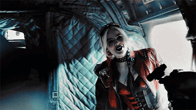 harley quinn from the movie suicide squad is holding a gun