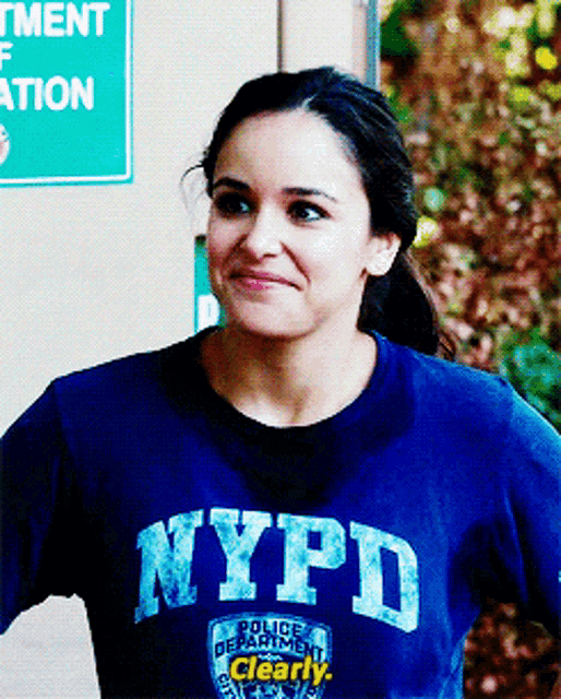a woman wearing a blue nypd sweatshirt is smiling