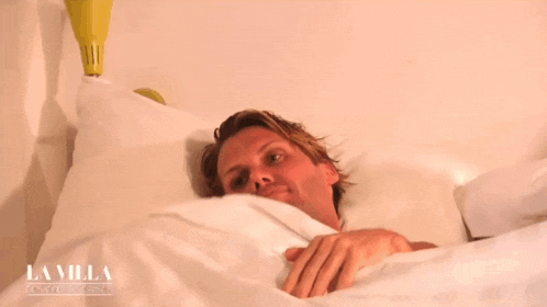 a man is laying in a bed with the word lavilla on the bottom right