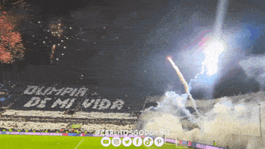 olympia de mi vida written on a soccer field with fireworks in the background