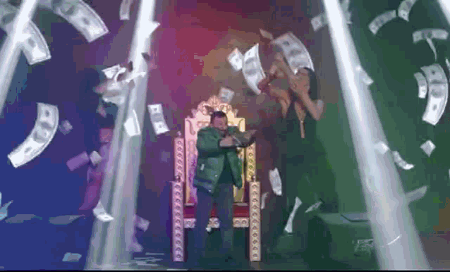 a man is sitting on a throne surrounded by money falling from the ceiling .
