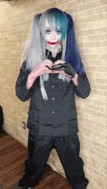 a person in a costume with blue and white hair is standing in front of a brick wall