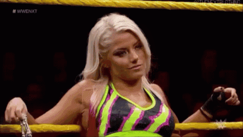 a woman is standing in a wrestling ring with a rope around her waist .