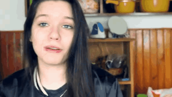a woman with long dark hair is making a face