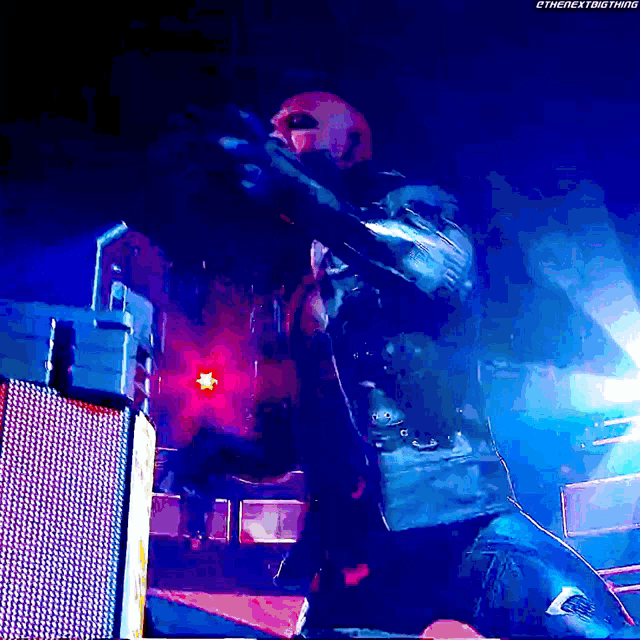 a man is kneeling down in front of a microphone with the next big thing written on the bottom
