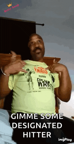 a man is wearing a yellow t-shirt that says gimme some designated hitter