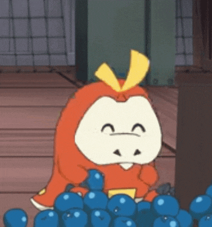a cartoon character dressed as an apple is sitting in a pile of blueberries .