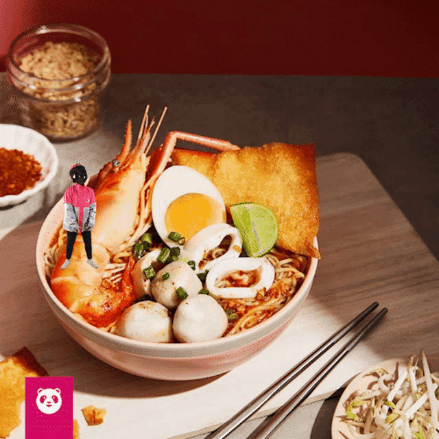a bowl of noodles with shrimp eggs and meatballs