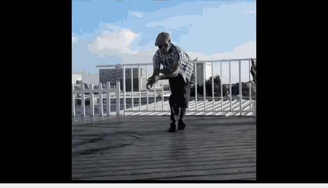 a man wearing a hat is dancing on a balcony