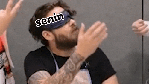a man with a beard is wearing a blindfold and clapping .