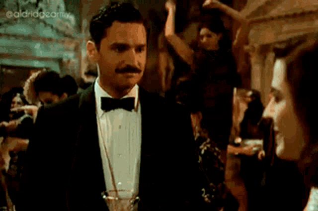 a woman in a black dress is holding a glass of champagne
