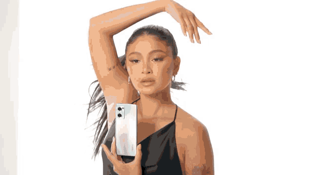 a woman in a black dress is taking a picture with her phone