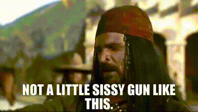 a man with a beard and a bandana on his head is standing in front of a group of people .