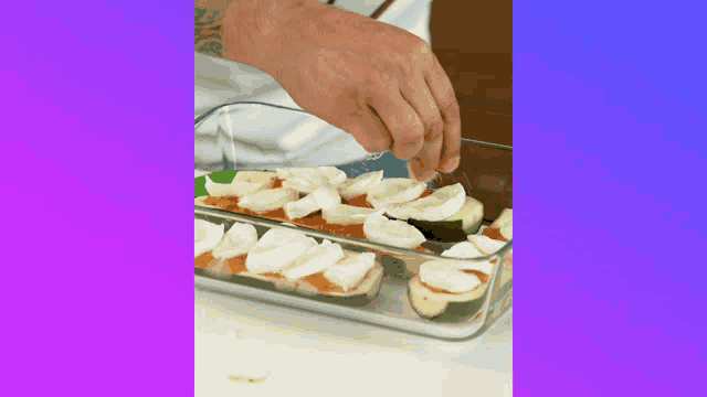 a person is adding mozzarella to a casserole dish of zucchini