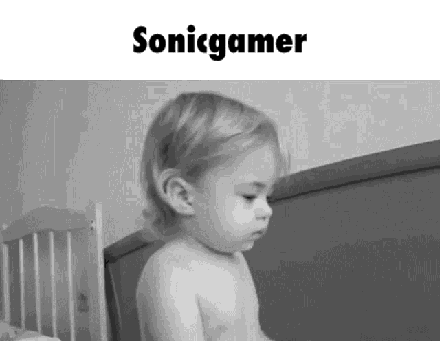 a black and white photo of a baby sitting in a crib with the words sonic gamer above it .