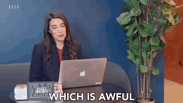 a woman sitting at a table with an apple laptop and the words which is awful