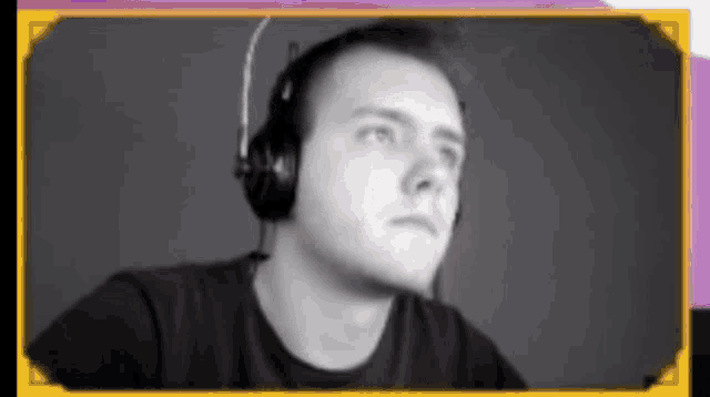 a man wearing headphones and a microphone looks at the camera